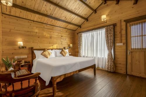 a bedroom with a bed in a wooden room at Bogmallo Beach Resort in Bogmolo