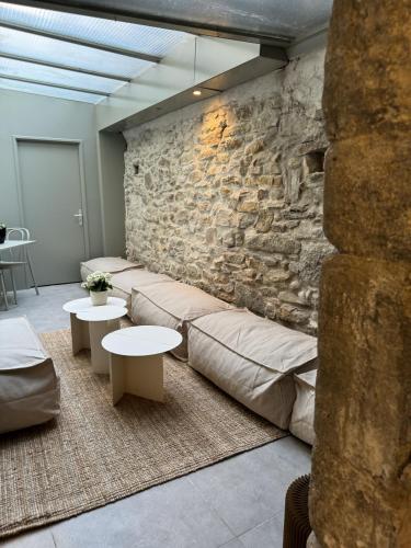 a room with couches and tables and a stone wall at La Demeure de la Cité by Jean Bacou in Carcassonne