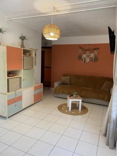 ein Wohnzimmer mit Sofa und Tisch in der Unterkunft La Bandolaise, studio 25m2 in Bandol