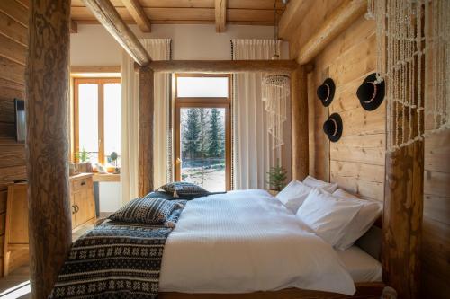 a bedroom with a bed in a room with a window at Niedźwiedzia Residence Garden Sauna in Poronin