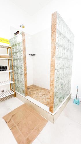 a room with a shower with glass panels at Anse Grosse Roche Beach Villa in La Digue