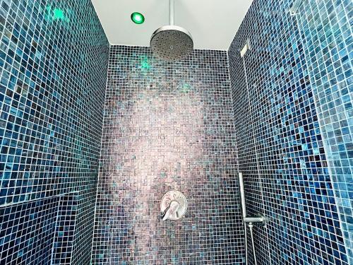 a shower with blue tiles on the wall at I piedi nell'acqua in Finale Ligure