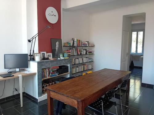- un salon avec une table en bois et une étagère à livres dans l'établissement Appartement - Toulon, à Toulon