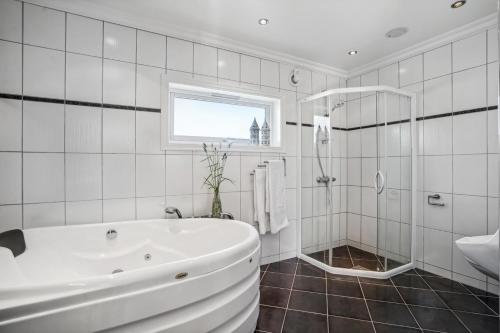 a white bathroom with a tub and a shower at ARCTIC HOMES - Villa Borealis in Tromsø