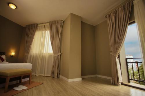 a bedroom with a bed and a large window at Haile Hotel Wolaita in Sodo