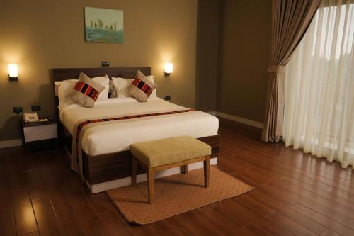 a bedroom with a large white bed with a wooden floor at Haile Hotel Wolaita in Sodo