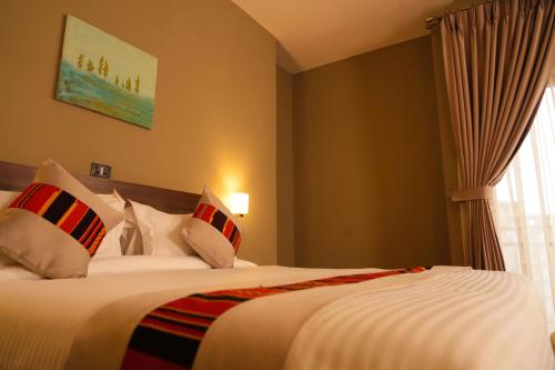 a bedroom with a large bed with a window at Haile Hotel Wolaita in Sodo