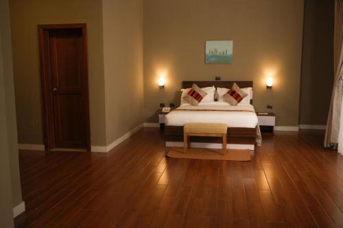 a bedroom with a bed and a wooden floor at Haile Hotel Wolaita in Sodo