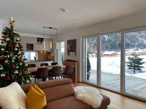 a living room with a christmas tree and a table at TYROL PURElife Lodges in Sankt Jakob in Defereggen