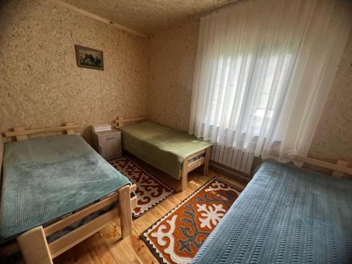a room with two beds and a window at Zhyluu Suu Resort BozUchuk in Novovoznesenovka
