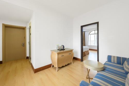 a living room with a blue couch and a table at Qingdao Liuying Jieli Hotel - Qingdao Station Trestle Bridge Branch in Qingdao