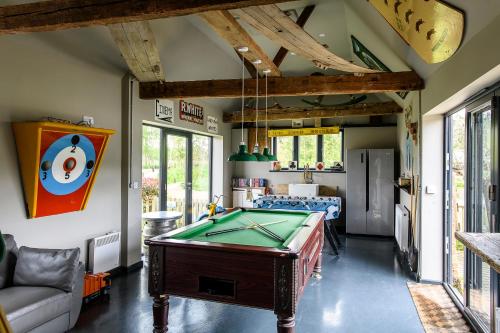 a living room with a pool table in it at Vineyard Oast Sleeps 25 in Wavehorne