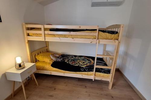 a room with two bunk beds and a desk at A l'ombre du chêne Piscine & Spa Gîtes Eden en Cévennes à Anduze Gard in Anduze