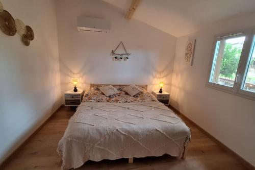 a bedroom with a bed with two lamps on two tables at A l'ombre du chêne Piscine & Spa Gîtes Eden en Cévennes à Anduze Gard in Anduze