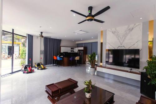 a living room with a ceiling fan and a television at Flamingo Hải Tiến - Lavender Villa 6 phòng ngủ in Nam Khê