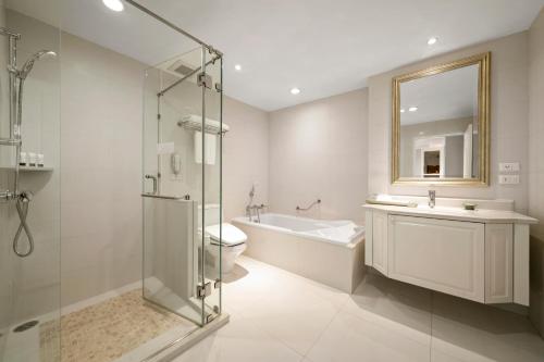 a bathroom with a shower and a toilet and a sink at Grande Centre Point Hotel Ratchadamri Bangkok in Bangkok