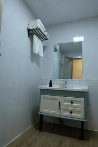 a bathroom with a sink and a mirror at Qingdao Liuying Jieli Hotel - Qingdao Station Trestle Bridge Branch in Qingdao
