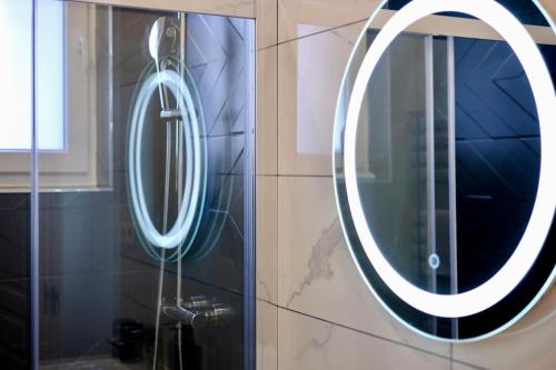 a bathroom with a round mirror on a wall at Rouen - Bienvenue chez Alice in Rouen