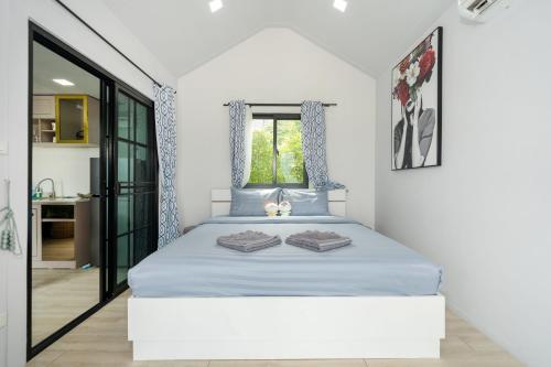 a bedroom with a bed with blue sheets and a window at 哦先生的海景别墅 Aoyon Beach in Phuket Town