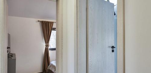 an open door to a bedroom with a window at Blissful Resort - Valea Doftanei in Teşila