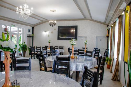a dining room with tables and chairs and chandeliers at Ge-Lux in Inceşti