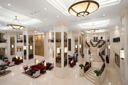 a lobby with a spiral staircase in a building at Grande Centre Point Hotel Ratchadamri Bangkok in Bangkok