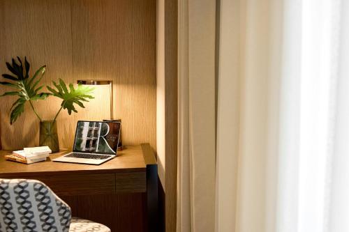 a laptop computer sitting on a desk in a room at REY Hotel Hanoi in Hanoi