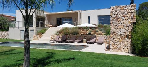 une maison avec une piscine avec chaises et parasols dans l'établissement Villa Arty Riviera, à Saint-Paul-de-Vence