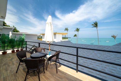 a patio with a table and chairs and an umbrella at 哦先生的海景别墅 Aoyon Beach in Phuket Town