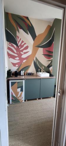 La salle de bains est pourvue d'un lavabo et d'une peinture murale. dans l'établissement Bellavista 2 - Chambre chez l'habitant, à Auch