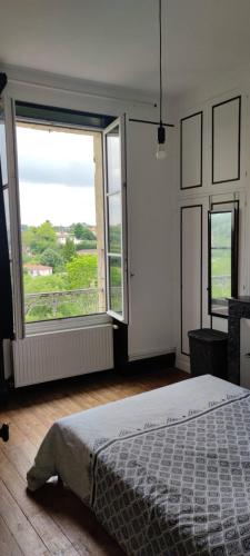 une chambre avec un lit et une grande fenêtre dans l'établissement Bellavista 2 - Chambre chez l'habitant, à Auch