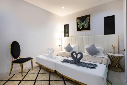 a bedroom with a bed with two swans on it at Nariya Bayfront Phuket in Ban Bang Chak