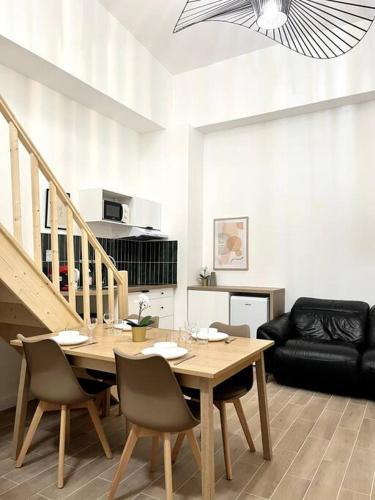 un salon avec une table et des chaises en bois dans l'établissement 736 Agréable studio mezzanine proche de Paris 20, à Bagnolet