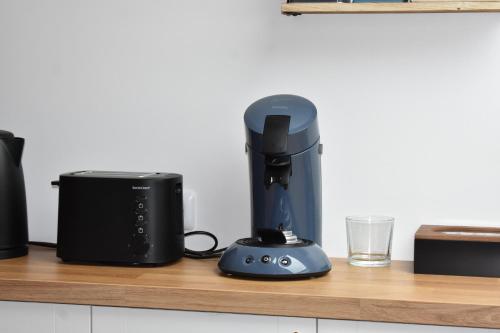 a black blender sitting on a counter next to a glass at Bords de l'Aure, Meublé de tourisme 3 étoiles in Bayeux