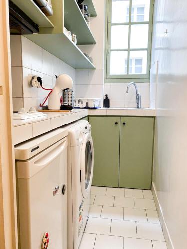une petite cuisine avec lave-linge et sèche-linge dans l'établissement une pièce Cosy à 5 Min de la Tour Eiffel à pied, à Paris