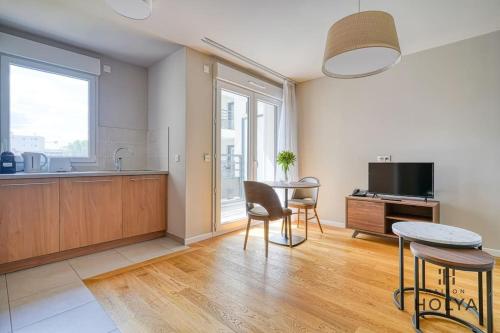 une cuisine et une salle à manger avec une table et des chaises dans l'établissement À deux pas de Paris - Le Gracieux - 363B, à Issy-les-Moulineaux