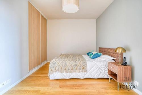 une chambre avec un lit et une table de chevet en bois dans l'établissement À deux pas de Paris - Le Gracieux - 363B, à Issy-les-Moulineaux