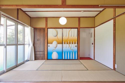a room with a door with a painting on it at Makiba in Hokuto