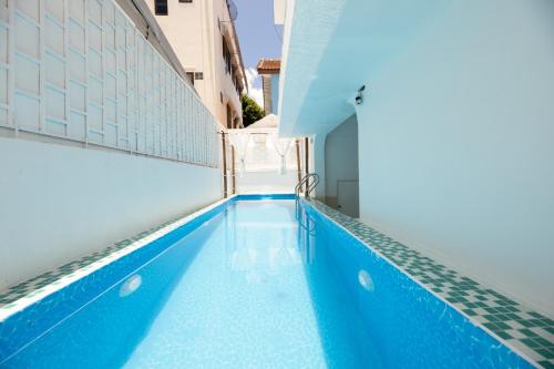 a blue swimming pool on the side of a building at Ratchada Retreat Boutique Suites in Bangkok