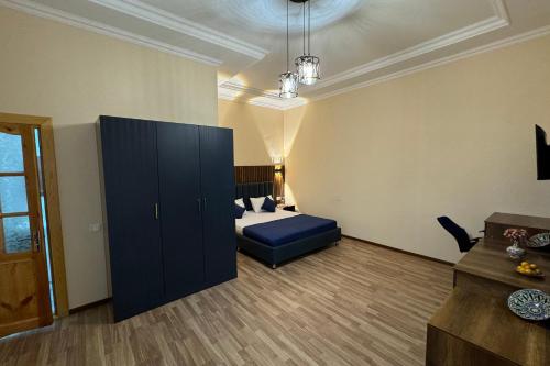 a bedroom with a bed and a blue cabinet at Guest House Shakuri in Samarkand