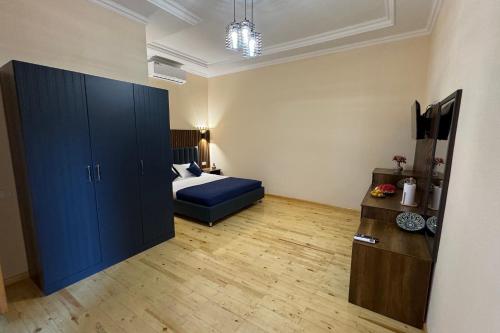 a bedroom with a bed and a blue cabinet at Guest House Shakuri in Samarkand