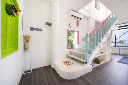a staircase in a home with green and white walls at 哦先生的海景别墅 Aoyon Beach in Phuket Town