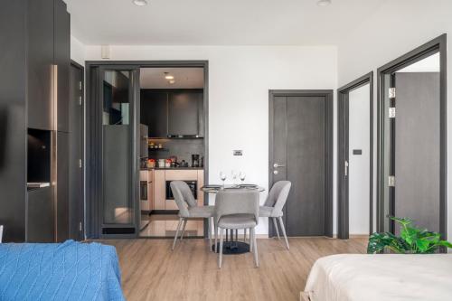 a room with a table and chairs and a kitchen at Vacaystation Edge Central Pattaya in Pattaya Central