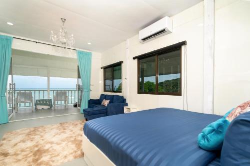 a bedroom with a blue bed and a couch and windows at 哦先生的海景别墅 Aoyon Beach in Phuket Town