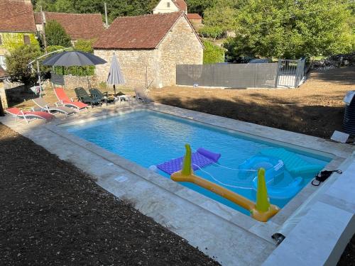 - une piscine avec toboggan dans la cour dans l'établissement La Callibetière, à Tourtoirac
