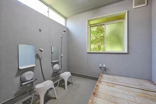 a bathroom with two toilets and a wooden table and a window at Makiba in Hokuto