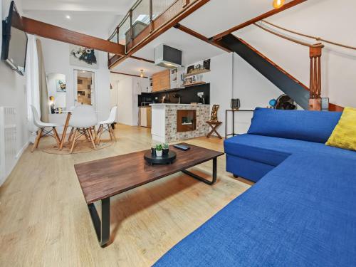 un salon avec un canapé bleu et une table dans l'établissement Loft Duplex à 2 min de Paris - Parking gratuit, à Le Pré-Saint-Gervais