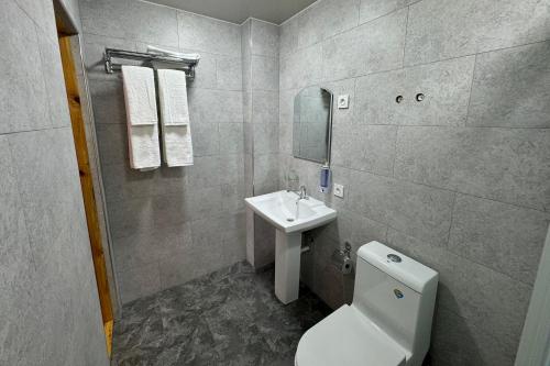 a bathroom with a white toilet and a sink at Guest House Shakuri in Samarkand
