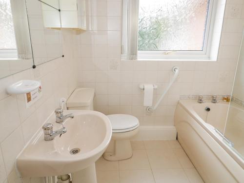a bathroom with a sink and a toilet and a bath tub at Breve Rest in Abergele