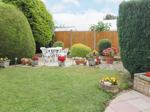 a backyard with a table and chairs and flowers at Breve Rest in Abergele